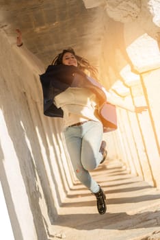 Beautiful and happy young girl jumping outdoors
