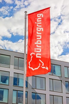 Nurburg, Germany - May 20, 2017: Flag at race track Nurburgring info center entrance, labeled with "Nurburgring"" and logo"