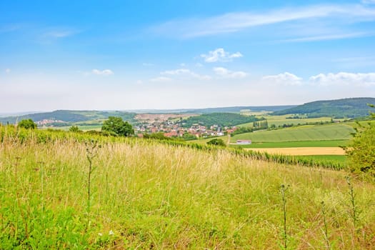 rural german landscape with meadow in foreground and blue sky