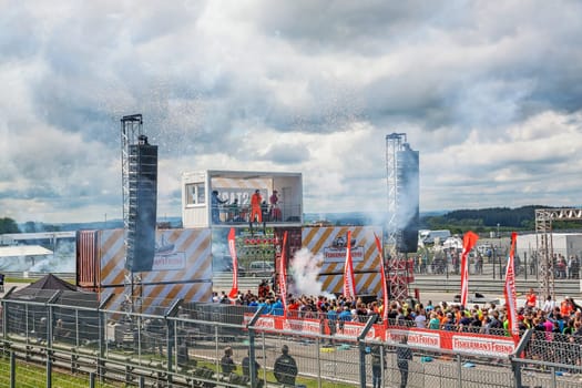 Nurburg, Germany - May 20, 2017: Fishermen's Friend Strongman RUN at race track Nurburgring - runners start with fireworks on start finishing straight in front of stage