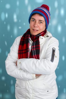 Woman with crossed arms in winter clothes with snowflakes