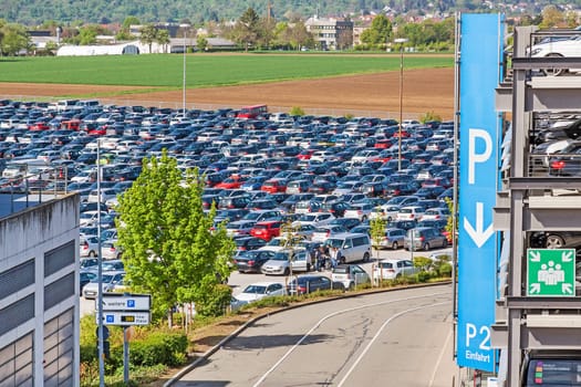 Airport parking lot with cars - parking garage with P sign aside