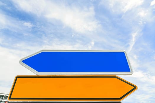 empty arrow traffic sign (bidirectional) pointing to different sides (left / right) - blue sky