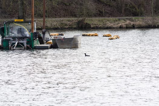 HEILIGENHAUS, NRW, GERMANY - MARCH 03, 2017:.Special ship, working platform in use on a small pond. Wet dredging at the Abtskuecher Teich in Heiligenhaus.