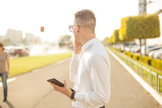 Businessman Man With Mobile Phone and Tablet computer in hands, In City, Urban Space