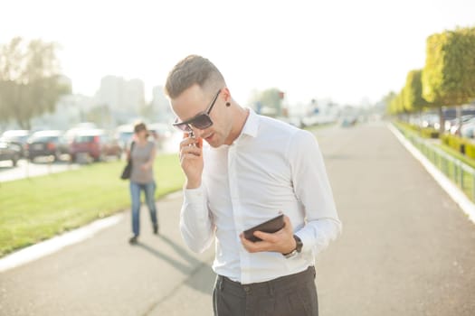 Businessman Man With Mobile Phone and Tablet computer in hands, In City, Urban Space