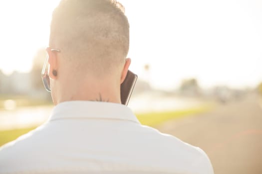 Man With Mobile Phone And Hat, In City, Urban Space, back view, outdoor