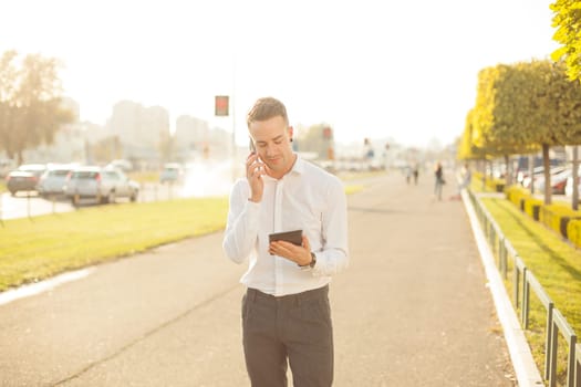 Businessman Man With Mobile Phone and Tablet computer in hands, In City, Urban Space