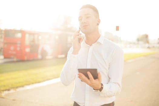 Businessman Man With Mobile Phone and Tablet computer in hands, In City, Urban Space