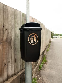 a public black bin on metal post isolated  England  UK