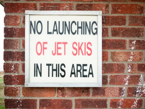 old retro sign lettering on wall saying no launching of jet skies in this area  England  UK