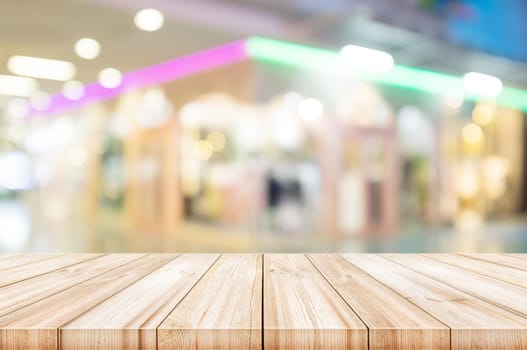 Empty wooden table top with blurred modern shopping mall background. can be used product display.