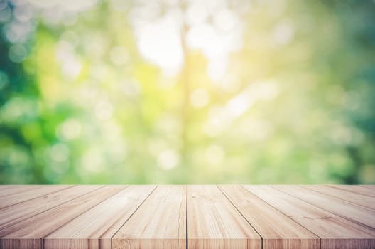 Empty wooden table top with blurred green natural abstract background. can be used product display. Vintage tone filter.