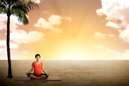 Pregnant woman doing yoga on the desert under coconut tree