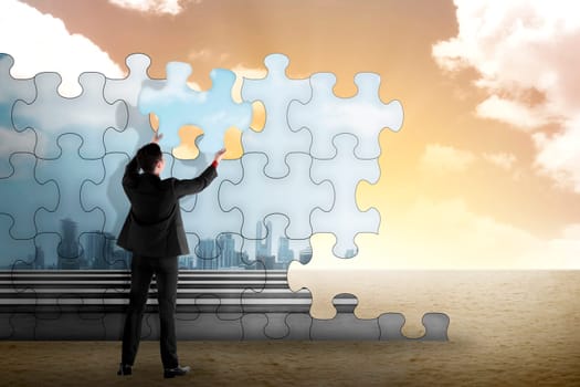 Business person building puzzle of city in the desert. Business building concept