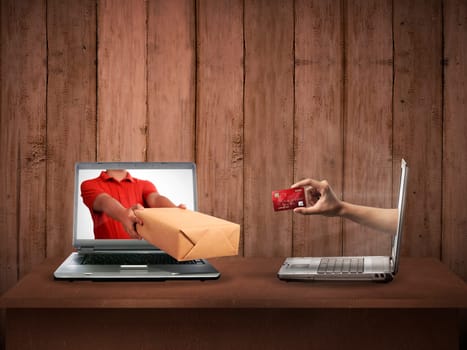 Hand giving a box out of laptop screen. Online shopping concept