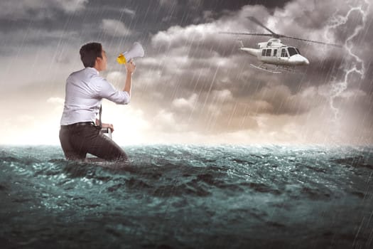 Asian business man calling help with bullhorn. He lost in the sea