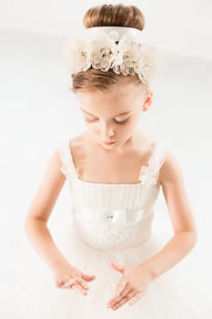 Little ballerina girl in a tutu. Adorable child dancing classical ballet in a white studio. Children dance. Kids performing. Young gifted dancer in a class. Preschool kid taking art lessons.
