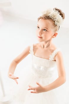 Little ballerina girl in a tutu. Adorable child dancing classical ballet in a white studio. Children dance. Kids performing. Young gifted dancer in a class. Preschool kid taking art lessons.