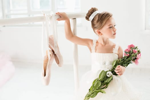Little ballerina girl in a tutu. Adorable child dancing classical ballet in a white studio. Children dance. Kids performing. Young gifted dancer in a class. Preschool kid taking art lessons.