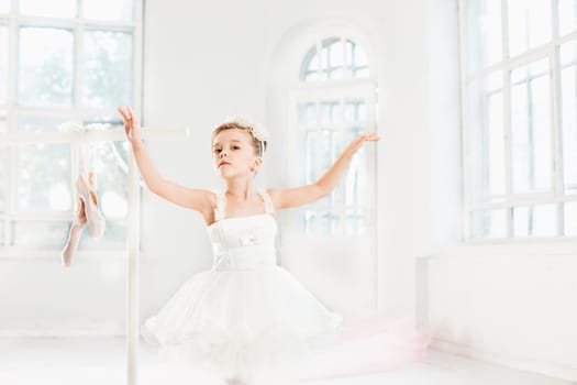 Little ballerina girl in a tutu. Adorable child dancing classical ballet in a white studio. Children dance. Kids performing. Young gifted dancer in a class. Preschool kid taking art lessons.
