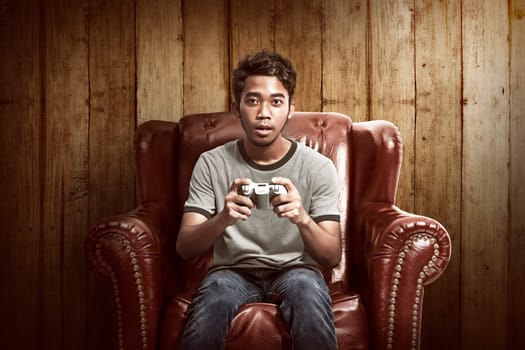 Portrait of asian man playing video games in his living room