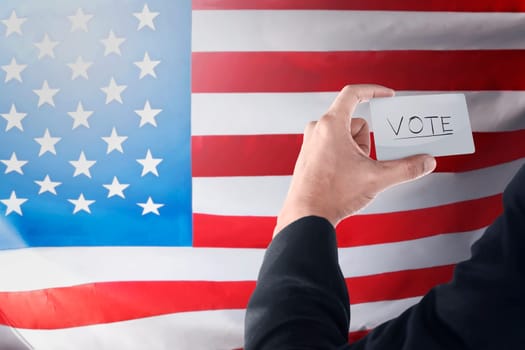 Businessman holding paper with 'VOTE' writing. Election day background or concept