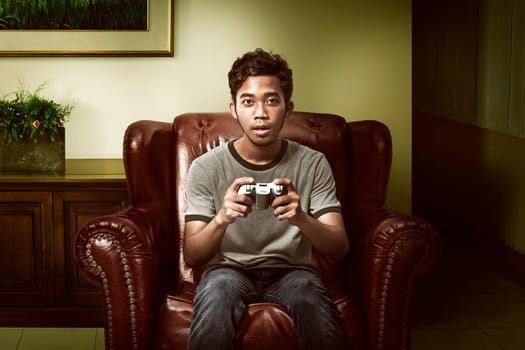 Asian man playing game on the living room