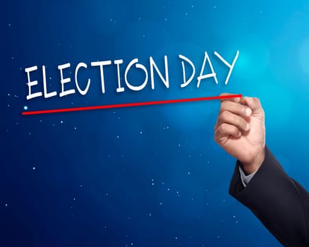 Man hand writing a 'ELECTION DAY' with gold marker on visual screen