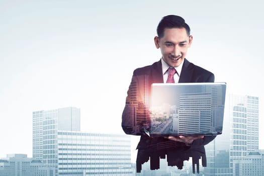 Double exposure of asian business man typing with laptop combined with building