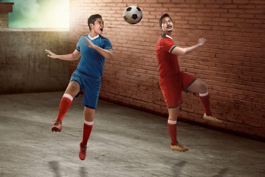 Image of soccer player header on the alley. Street soccer concept
