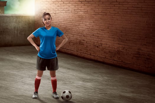 Image of young female soccer player standing on the alley