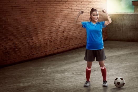 Image of young female soccer player standing on the alley