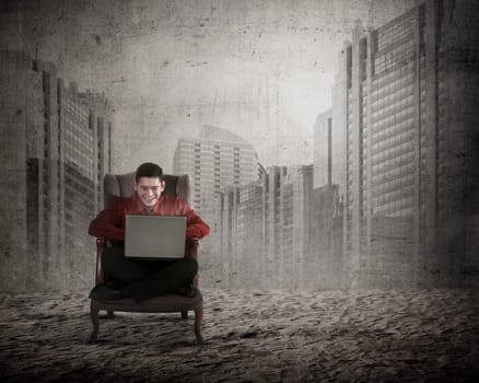 Asian business man sitting on the chair typing with laptop