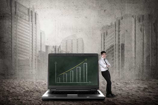 Asian business man leaning on big laptop, show report