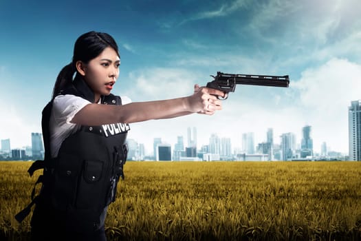 Beautiful police woman holding gun ready to fire