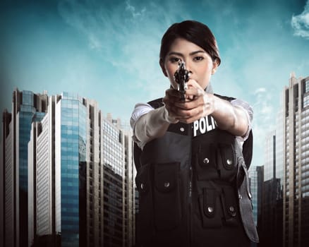 Beautiful police woman holding gun ready to fire