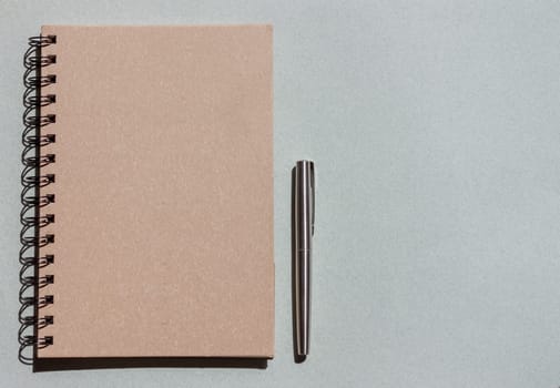 top view craft notebook and pen on blue background
