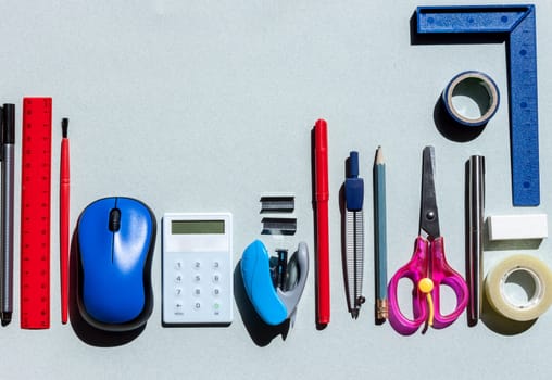 school stationery on blue paper background with copyspace