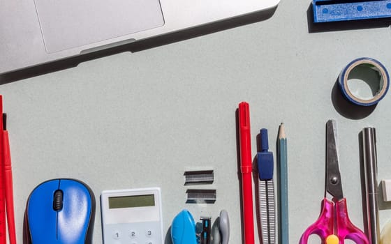 school stationery on blue paper background with copyspace