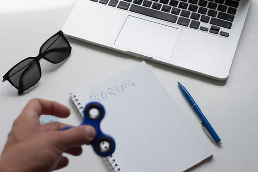 work desk with laptop mouse glasses and spinner