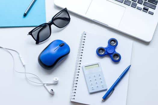 work desk with laptop mouse glasses and spinner