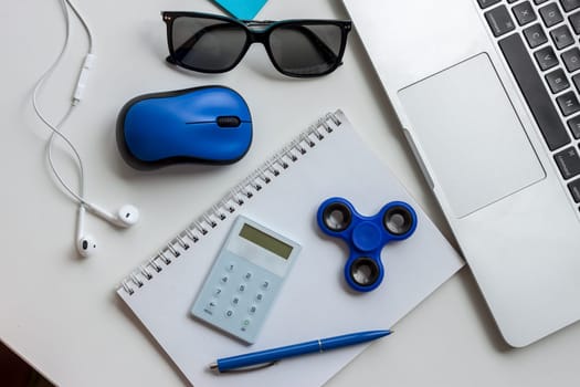 work desk with laptop mouse glasses and spinner