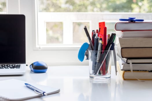 work desk with stationery laptop and books light background