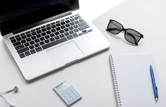 work desk with laptop notebook and glasses