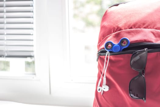 red backpack with school supplies on light background