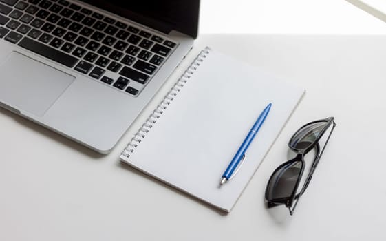 work desk with laptop notebook and glasses