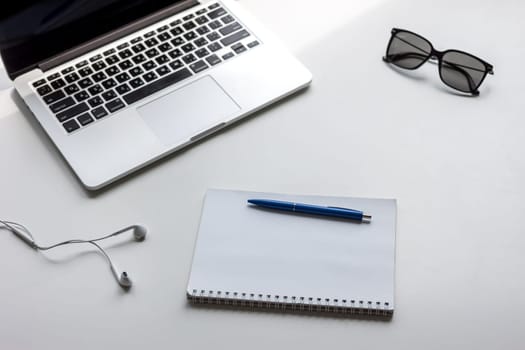 work desk with laptop notebook and glasses