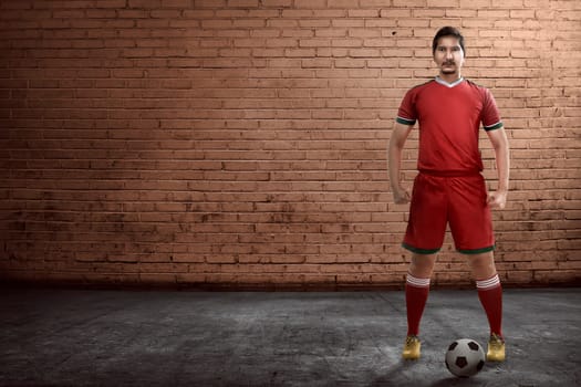 Asian football player standing on the alley ready playing street soccer
