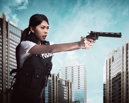 Beautiful police woman holding gun ready to fire
